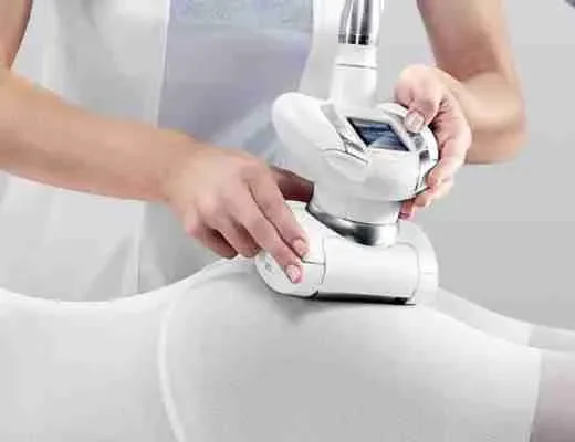 Technicienne utilisant un appareil esthétique sur la cuisse d’une cliente